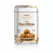 A tin of Rajamudi Dink NutriBites energy bites, with the product name and benefits listed on the label, surrounded by dry fruits such as almonds and seeds, and individual bites visible in the foreground.